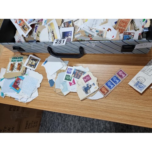 251 - A case containing a very large quantity of loose unsorted stamps mostly British and a bag full of mo... 