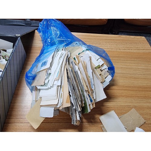 251 - A case containing a very large quantity of loose unsorted stamps mostly British and a bag full of mo... 