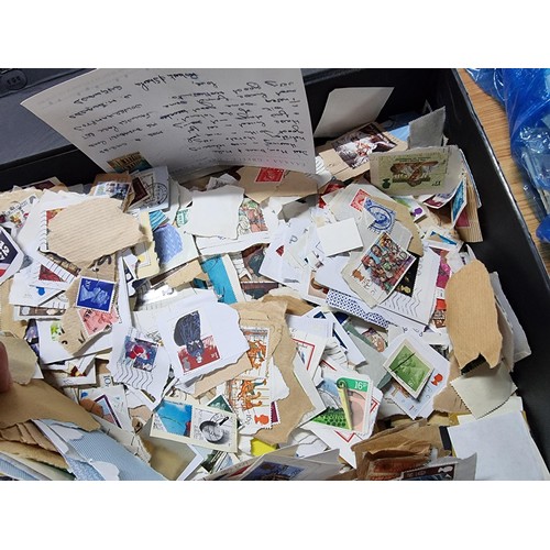 251 - A case containing a very large quantity of loose unsorted stamps mostly British and a bag full of mo... 