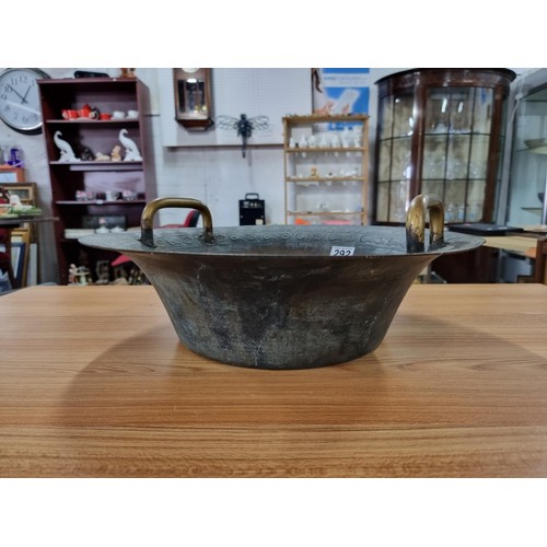 292 - A large antique Chinese bronze water basin with a dragon design featuring a ying yang and character ... 