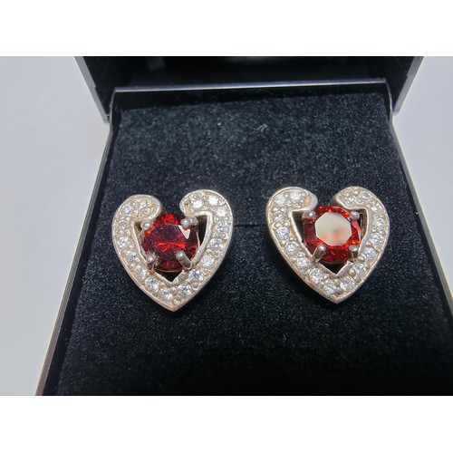 344 - A pair of pretty 925 silver heart formed stud earrings inset with large red stones and smaller white... 