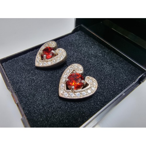 344 - A pair of pretty 925 silver heart formed stud earrings inset with large red stones and smaller white... 