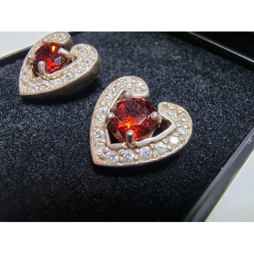 344 - A pair of pretty 925 silver heart formed stud earrings inset with large red stones and smaller white... 