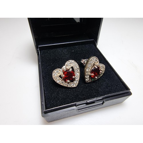 344 - A pair of pretty 925 silver heart formed stud earrings inset with large red stones and smaller white... 