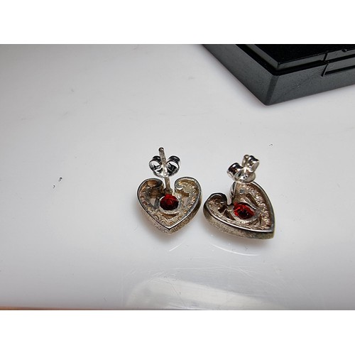 344 - A pair of pretty 925 silver heart formed stud earrings inset with large red stones and smaller white... 