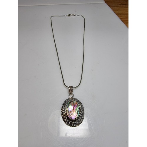 347 - A large 925 silver pendant inset with a large piece of abalone shell which presents good colours, se... 