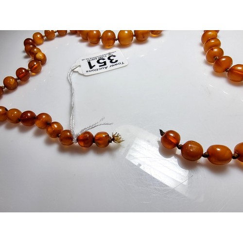 351 - A large vintage genuine egg yolk amber hand knotted beaded necklace, featuring graduated amber beads... 