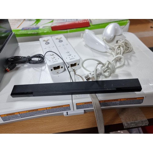 207 - A Nintendo Wii gaming console with dock, Wii fit plus board, 2 Wiiimote controllers and 2 nun chuck ... 