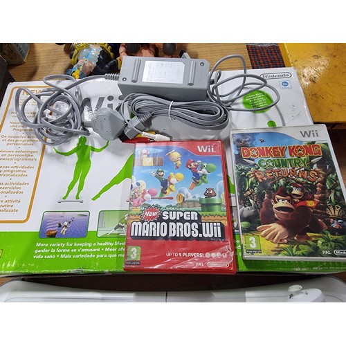 207 - A Nintendo Wii gaming console with dock, Wii fit plus board, 2 Wiiimote controllers and 2 nun chuck ... 