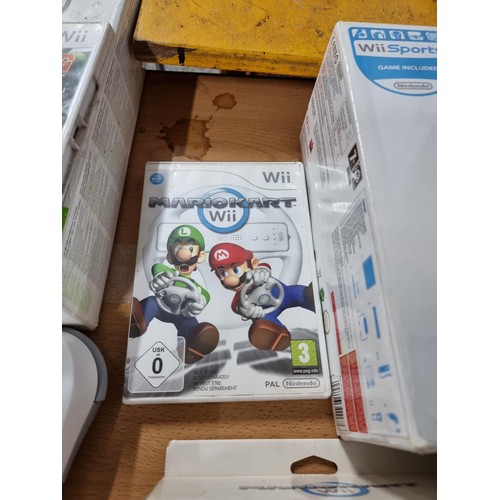 210 - A boxed Nintendo Wii games console along with a Mario Kart game and steering wheel, also a bundle of... 