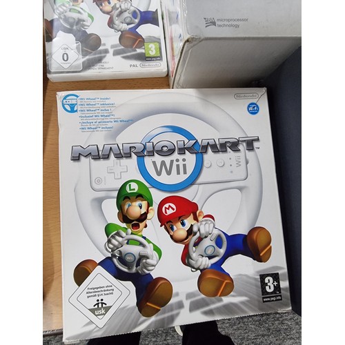 210 - A boxed Nintendo Wii games console along with a Mario Kart game and steering wheel, also a bundle of... 