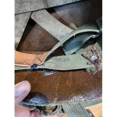 238 - A vintage military helmet with a green mesh netting, has marking to the inside of the helmet. Please... 