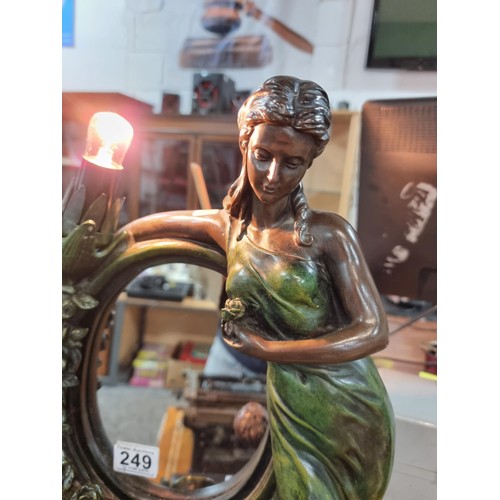 249 - An impressive large figural lamp featuring a mirror with a lady and cherub design, in good clean wor... 