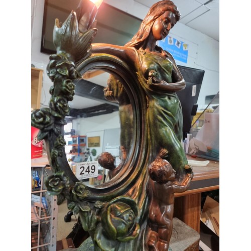 249 - An impressive large figural lamp featuring a mirror with a lady and cherub design, in good clean wor... 