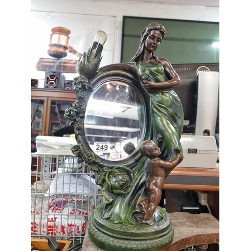 249 - An impressive large figural lamp featuring a mirror with a lady and cherub design, in good clean wor... 