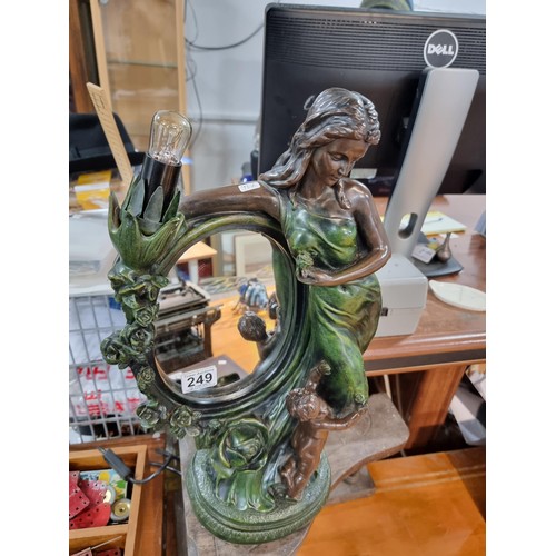 249 - An impressive large figural lamp featuring a mirror with a lady and cherub design, in good clean wor... 