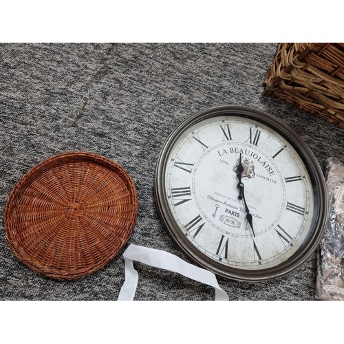 255 - A large wicker linen basket containing a large quantity of fabric tote bags, a large wall clock, a t... 