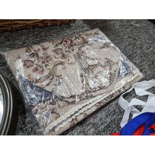 255 - A large wicker linen basket containing a large quantity of fabric tote bags, a large wall clock, a t... 