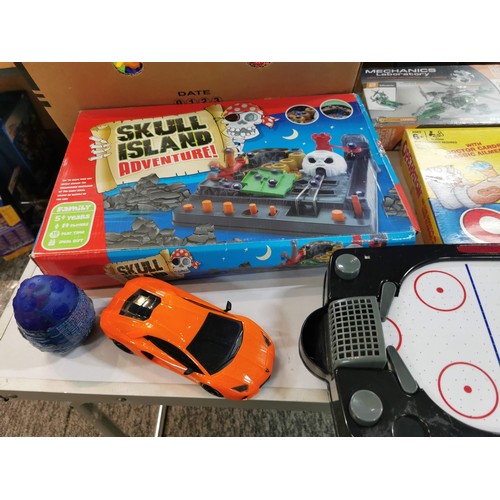 275 - A box of toys and games, many are unopened, to include a small air hockey game, various action figur... 
