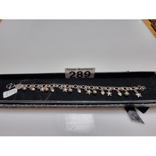 289 - A 925 silver bracelet with star, heart and bell charms, in clean condition and boxed. Length 7