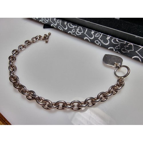 292 - A good quality chunky 925 silver bracelet with a silver charm to one end and a T bar to the other. I... 