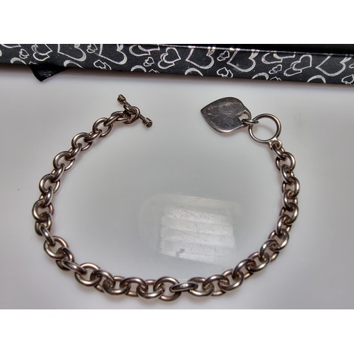 292 - A good quality chunky 925 silver bracelet with a silver charm to one end and a T bar to the other. I... 