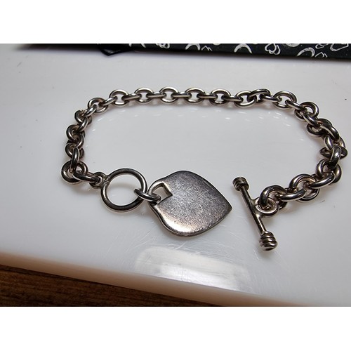 292 - A good quality chunky 925 silver bracelet with a silver charm to one end and a T bar to the other. I... 