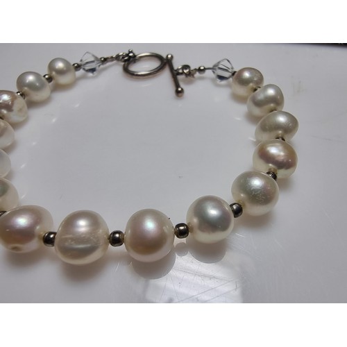 293 - A 925 silver, real pearl bracelet with glass charms to the end. In clean condition, boxed, length of... 