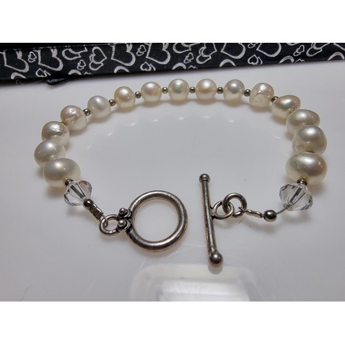 293 - A 925 silver, real pearl bracelet with glass charms to the end. In clean condition, boxed, length of... 