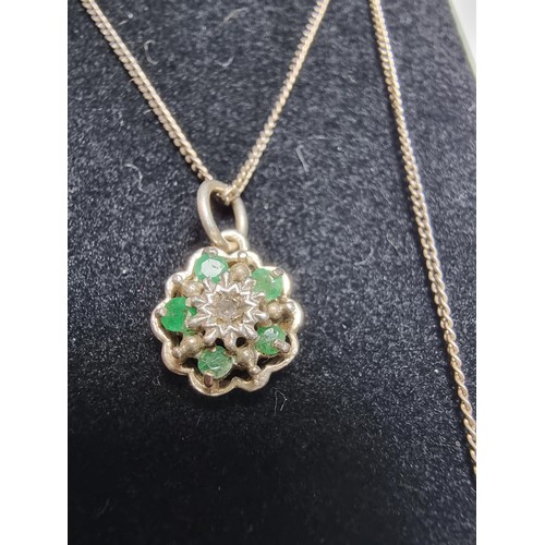 310 - A pretty 925 silver pendant inset with 5 emerald stones and a diamond to the centre on an 18