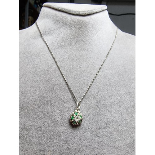 310 - A pretty 925 silver pendant inset with 5 emerald stones and a diamond to the centre on an 18
