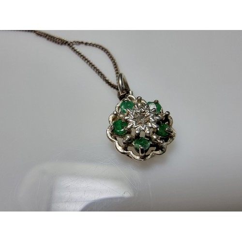 310 - A pretty 925 silver pendant inset with 5 emerald stones and a diamond to the centre on an 18