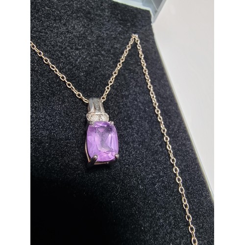 312 - A hallmarked 9ct white gold pendant inset with a large Amethyst gemstones and 2 diamonds set on an 1... 
