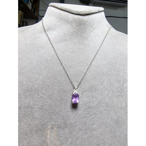 312 - A hallmarked 9ct white gold pendant inset with a large Amethyst gemstones and 2 diamonds set on an 1... 