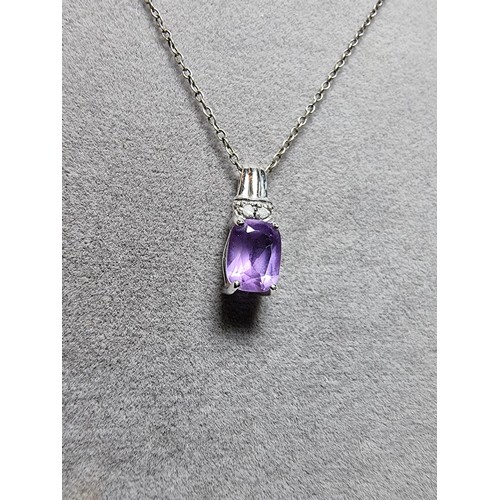312 - A hallmarked 9ct white gold pendant inset with a large Amethyst gemstones and 2 diamonds set on an 1... 