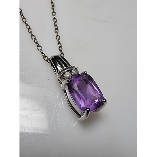 312 - A hallmarked 9ct white gold pendant inset with a large Amethyst gemstones and 2 diamonds set on an 1... 