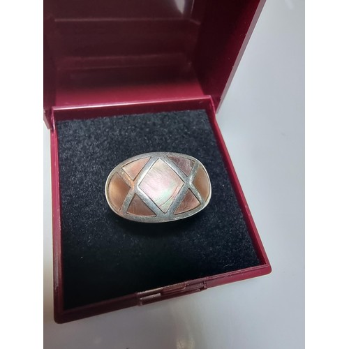 328 - A 925 silver ring inset with mother of pearl which represents good flashing colours, in good clean c... 
