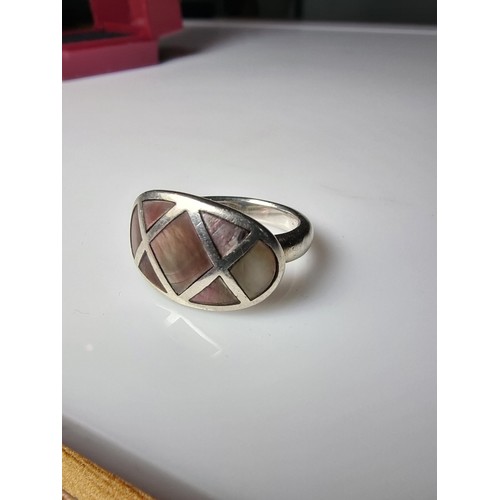 328 - A 925 silver ring inset with mother of pearl which represents good flashing colours, in good clean c... 