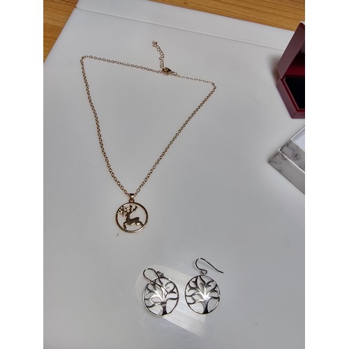 330 - A pair of unused 925 silver earrings with a tree design along with an unused gold plated deer pendan... 