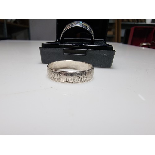 333 - An as new Tungsten carbide ring with colourful abalone shell all the way around along with a sterlin... 