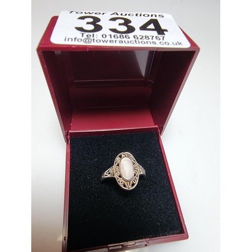 334 - A 925 silver ring with an ornate pierced design featuring mother of pearl to the centre. In clean co... 