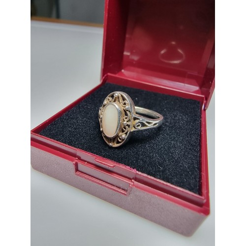 334 - A 925 silver ring with an ornate pierced design featuring mother of pearl to the centre. In clean co... 