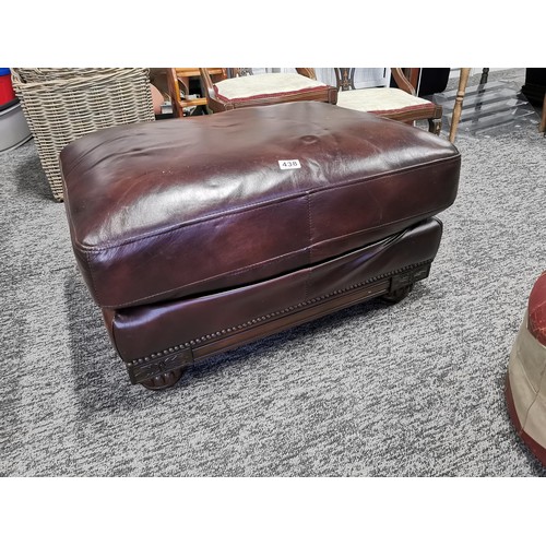 438 - Vintage circular red and grey leather pouffe in good order along with a large leather wooden based f... 