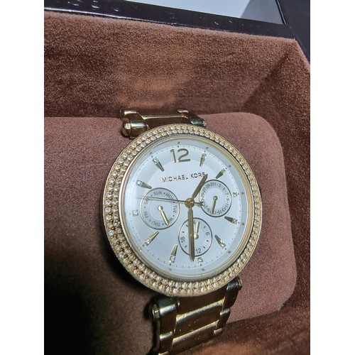 349 - An attractive unisex chronograph watch by Michael Kors with a jewelled bezel and gold tone strap, co... 
