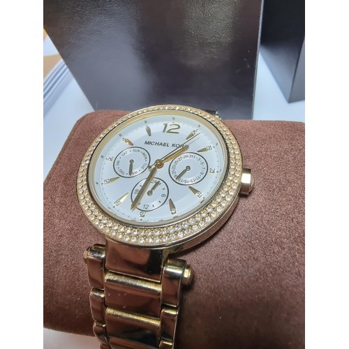 349 - An attractive unisex chronograph watch by Michael Kors with a jewelled bezel and gold tone strap, co... 