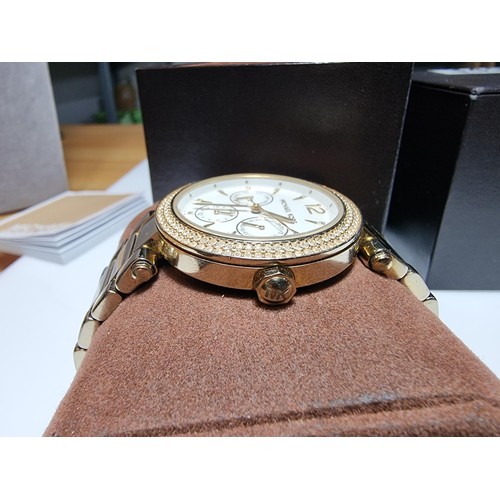 349 - An attractive unisex chronograph watch by Michael Kors with a jewelled bezel and gold tone strap, co... 