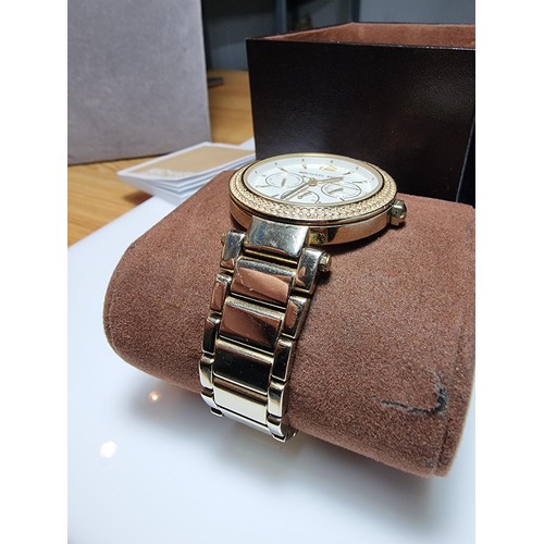 349 - An attractive unisex chronograph watch by Michael Kors with a jewelled bezel and gold tone strap, co... 