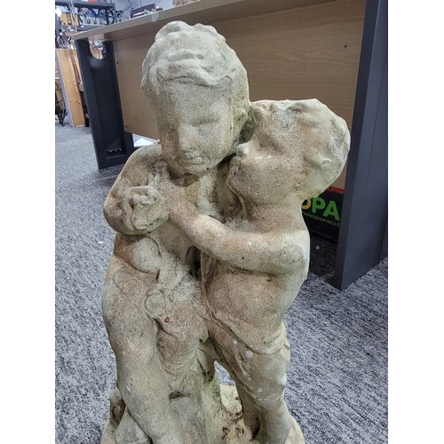 18 - Stoneware garden ornament of two children cuddling in overall good condition, stands at 56.5cm width... 