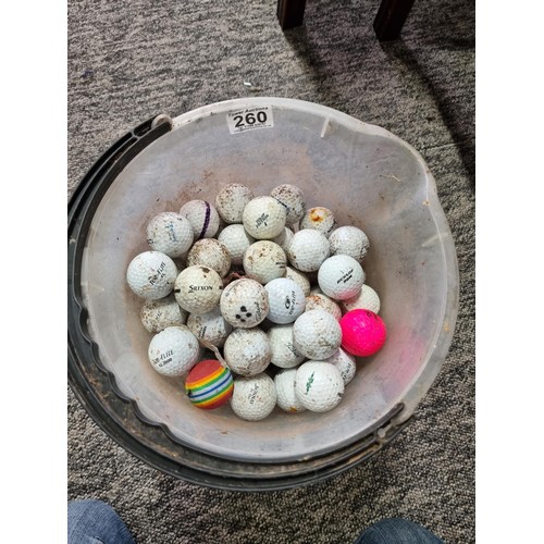 260 - A bucket full of various branded golf balls.