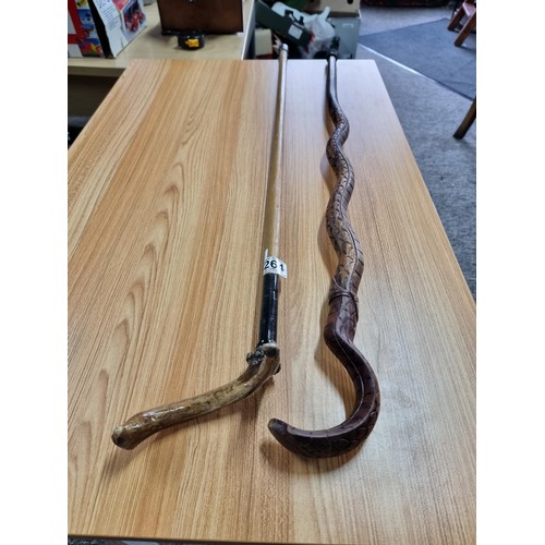 264 - 2 walking sticks, a carved cobra walking stick (has an old repair to the top) the other stick has an... 